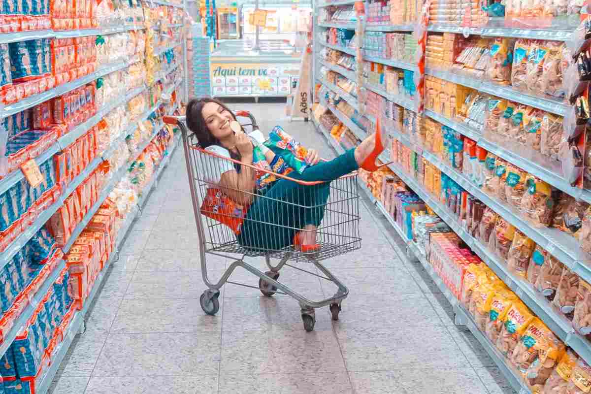 Ragazza dentro il carrella della spesa