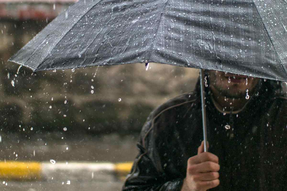 Uomo passeggia con l'ombrello
