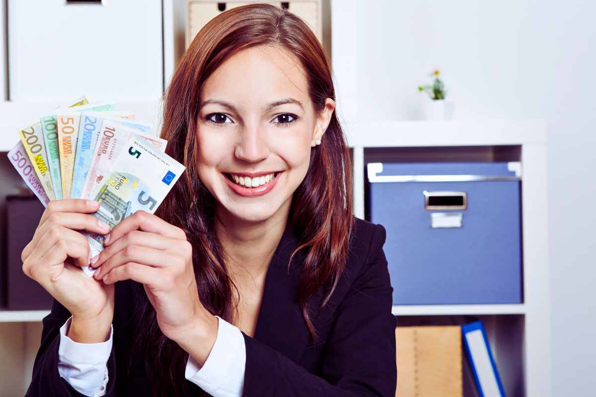 donna in ufficio con soldi in mano