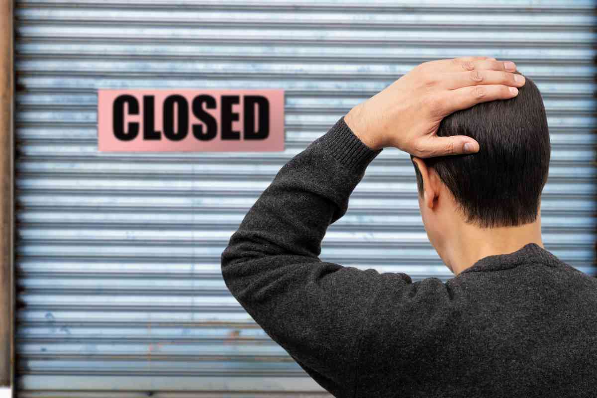 uomo davanti a negozio chiuso